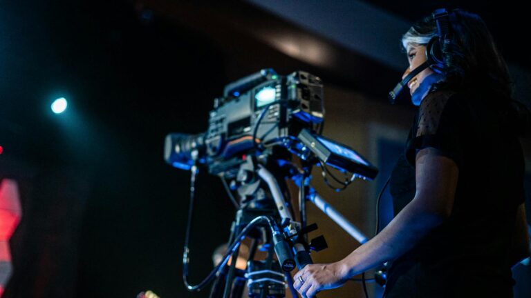 Cheerful female videographer shooting event